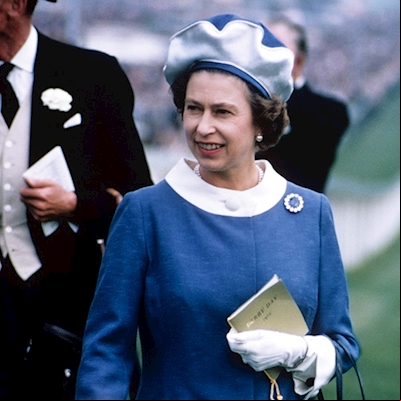 A young Queen wearing a blue dress with a white collar holding a racecard